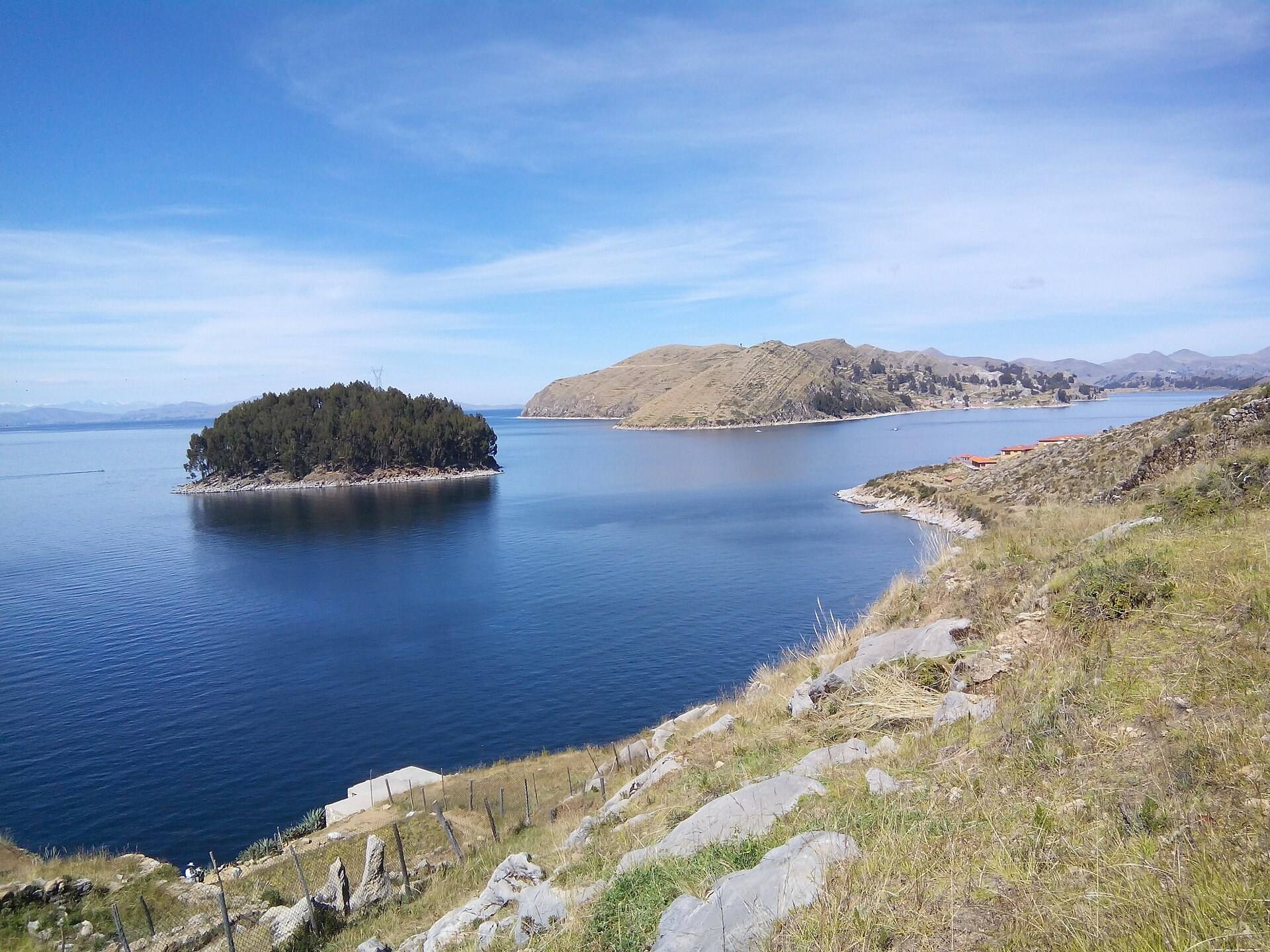 Blue water and a small wooded shore beside Isla del Sol.